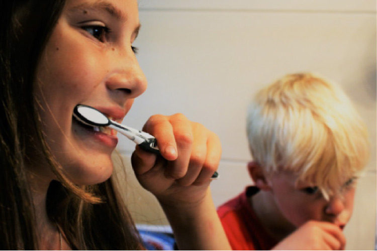 young boy and girl brushing their teeth