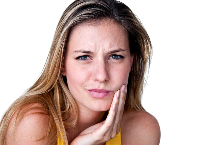 blond woman holding her cheek with a sore tooth