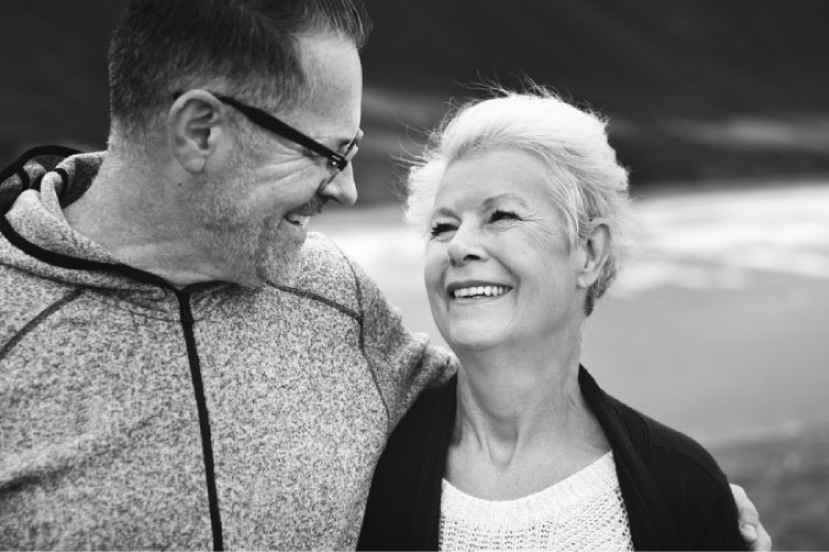 elderly couple look at each other and smile knowing they don't have gum disease