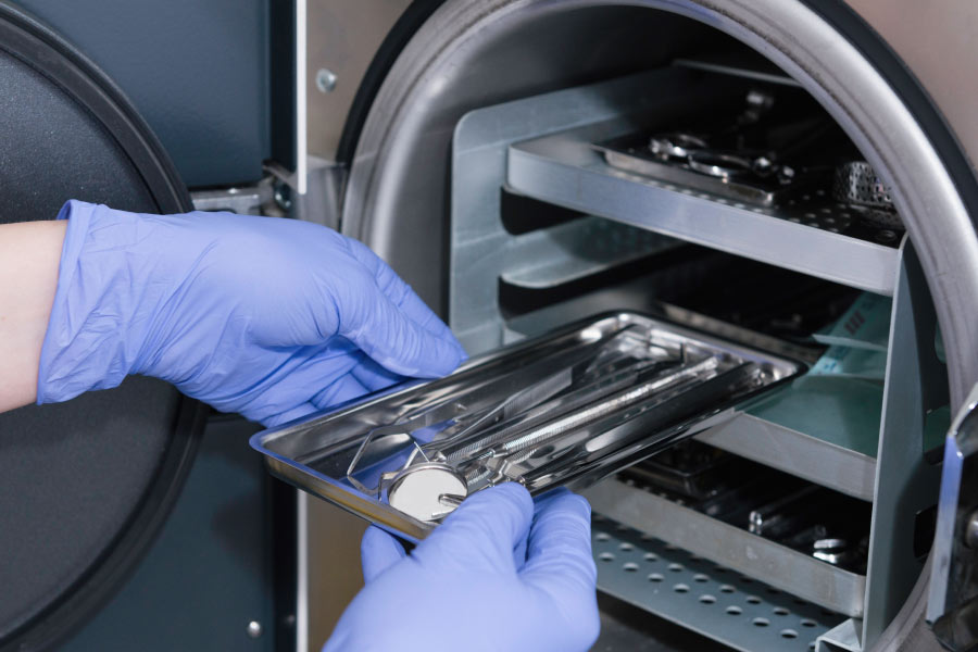 Gloved hands sterilizing equipment in a machine