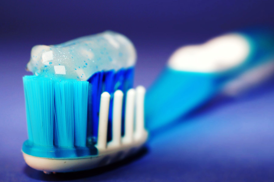 Closeup of a toothbrush loaded with toothpaste on a blue background 
