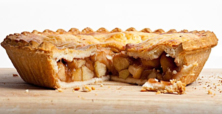 Side view of a delicious looking apple pie with one large piece removed