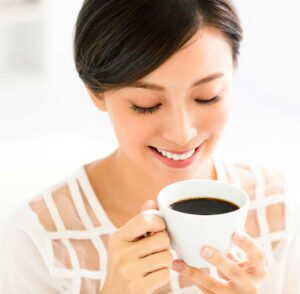 woman drinking coffee causing tooth discoloration